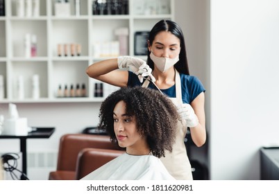 Hairdresser in protective mask cutting hair of curly african american client in beauty salon, free space - Powered by Shutterstock