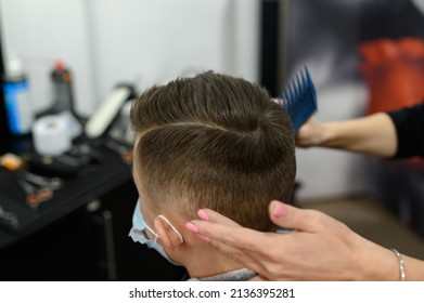 Hairdresser puts hair to teen boy after haircut, haircut for teen, styling after haircut with gel and comb.