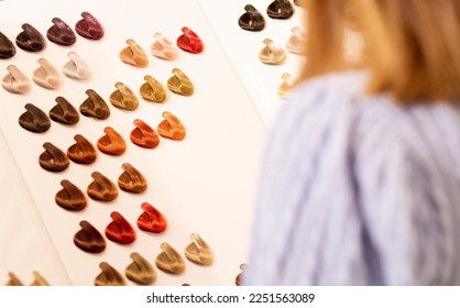 Hairdresser salon Woman chooses, looks at hair color samples on palette swatch book in stylist office or home. Beautician,dyeing,changing hair colour,natural,non-toxic,safe haircare concept Horizontal - Shutterstock ID 2251563089