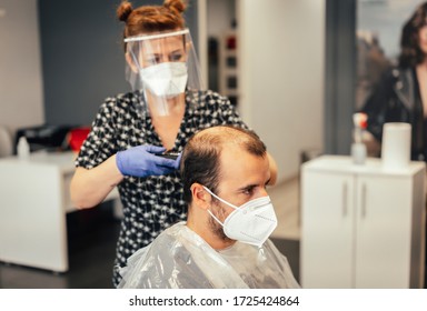 Hairdresser With Security Measures For The Covid-19, New Normality, Social Distance, Cutting Hair With A Mask