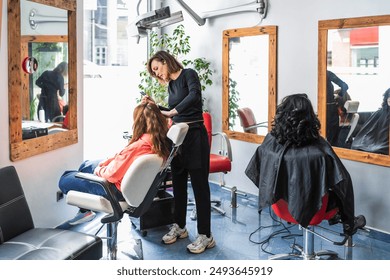 A hairdresser styles a client's hair in a bright, modern salon. The scene highlights the professional and friendly atmosphere. Concept of stylish hair salon. - Powered by Shutterstock