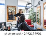 A hairdresser styles a client