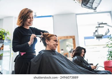 A hairdresser styles a client's hair in a modern salon, creating a neat bun. Concept of professional styling and client satisfaction. - Powered by Shutterstock