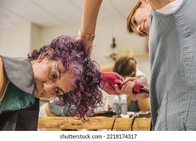 Hairdresser Styling A Client. Hairdresser At Her Work Station Styling And Drying The Hair Of A Mature Woman In The Beauty Salon.