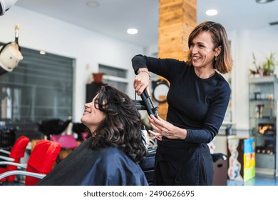 A hairdresser uses a curling iron to curl a client's hair in a modern salon. The setting is professional and stylish. Concept of professional hair curling. - Powered by Shutterstock