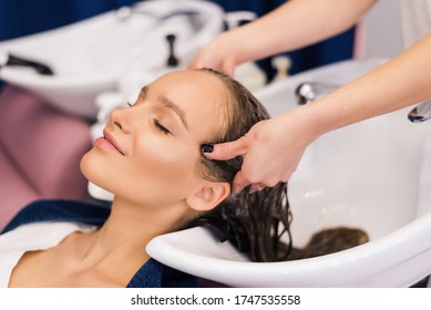 Hairdresser Washing Hair Of Happy Young Woman, Girl And Do Relaxing Massage At Beauty Saloon