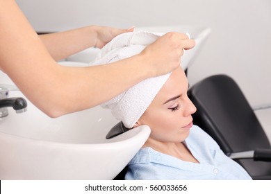 Hairdresser wrapping towel on customer's head - Powered by Shutterstock