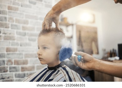 Hairdresser's hands cleaning small kid after styling his hair at barber shop. - Powered by Shutterstock