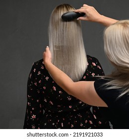 Hairdresser's Hands Combing Model's Hair From Behind