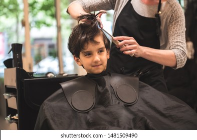 Hairdressers hands making hairstyle to child little boy in the barber shop hair cut professional - Little boy in the barber shop hair cut professional toddler child getting his first haircut smiling