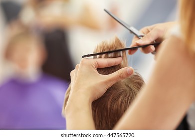 Hairdresser's hands making hairstyle to child