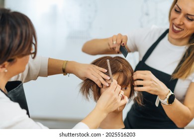 Hairdressers Training with Mannequin Head in Education Center. Professional female hairdresser teaching adult students haircutting technique.