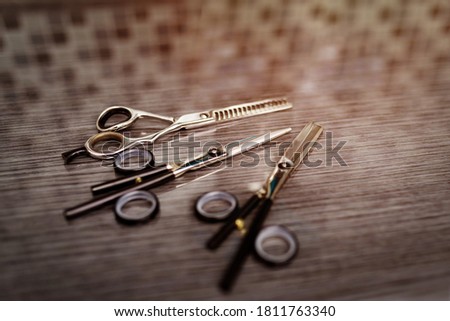 Hairdressing different scissors on table in professional hairdressing salon. Selective focus