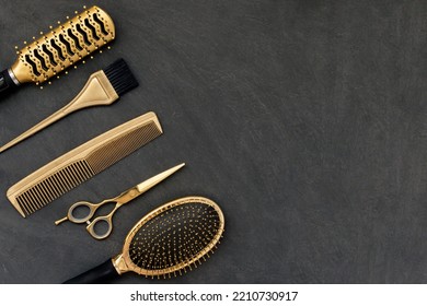 Hairdressing tools in gold on gray concrete background. Hair salon accessories, combs, scissors in the corner and copy space - Powered by Shutterstock