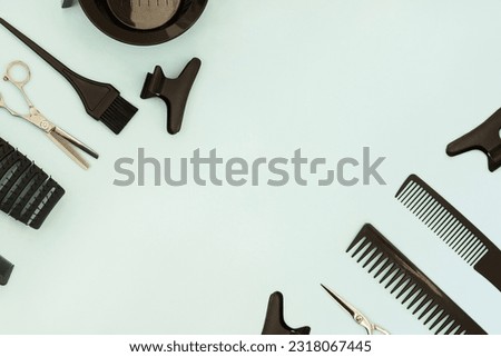 Hairdressing tools scissors combs on  pastel green blue background. Horizontal template with hair salon accessories and copy space