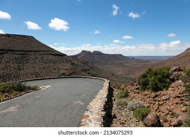 Hairpin bend in a road overlooking a valley and mountains in the Karoo National Park