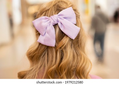 Hairstyle On Long Blond Curly Hair: Lilac Bow On The Back Of The Head, Back View, Close-up