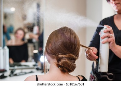 Hairstyling process in a beauty salon. Hairdresser fixing woman hair with hairspray. Wedding hairdo. - Powered by Shutterstock