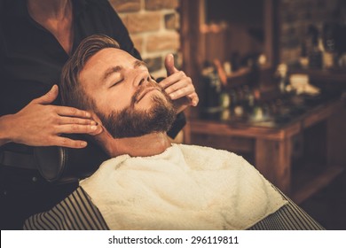 Hairstylist applying after shaving lotion in barber shop - Powered by Shutterstock