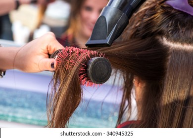 Hairstylist brushing hair with a hairdryer - Shutterstock ID 340945325