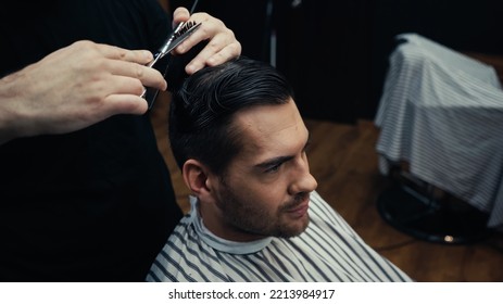 Hairstylist Cutting Hair Of Man In Hairdressing Cape In Salon