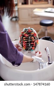 Hairstylist Doing A Perm Placing A Heairnet Over The Tightly Rolled Curlers In A Customers Hair Before Applying The Perming Lotion