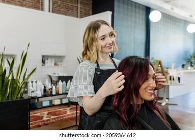 Hairstylist giving a haircut to a customer at a beauty salon - Powered by Shutterstock