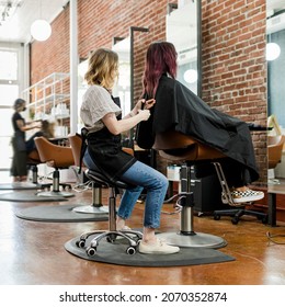 Hairstylist giving a haircut to a customer at a beauty salon - Powered by Shutterstock