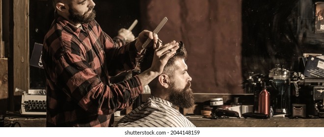 Hairstylist serving client at barber shop. Man visiting hairstylist in barbershop. Bearded man in barbershop. Work in the barber shop. Man hairstylist.