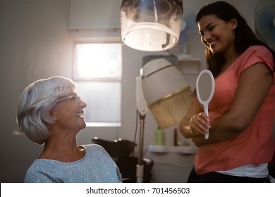 Hairstylist talking to senior woman in salon - Powered by Shutterstock