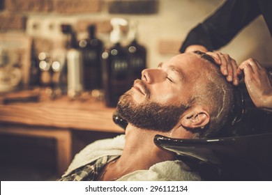 Hairstylist washing client's hair in barber shop - Powered by Shutterstock