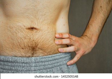 The Hairy Belly Of A Young Man. Athletic Build. Gray Pants. Naked Torso.Close Up.