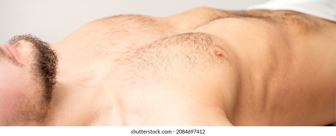 Hairy Body, Stomach, And Chest Of A Man Lying Before Epilation