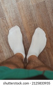 Hairy male legs on the floor in short white socks - Shutterstock ID 2125833935