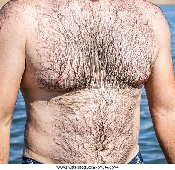 Hairy torso of a man on the beach 