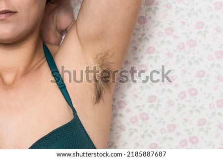 Hairy woman armpit. Woman without waxing. Unplucked hair. Woman showing natural body hair without shaving. Hair growing in the armpit with the barazos without shaving. self confident girl. Hairy woman