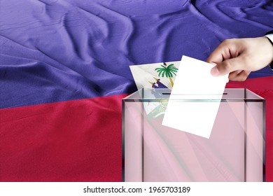 haiti flag, haiti  the symbol of elections Male hand puts down a white sheet of paper with a mark as a symbol of a ballot paper against the background
