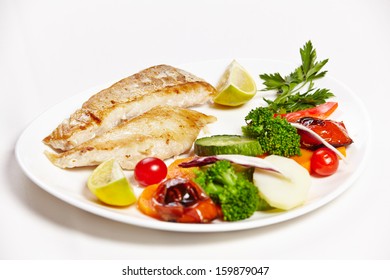 Hake Filet Grille With Steamed Vegetables On A Plate In A Restaurant