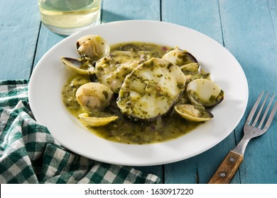 Hake Fish And Clams With Green Sauce On Blue Wooden Table