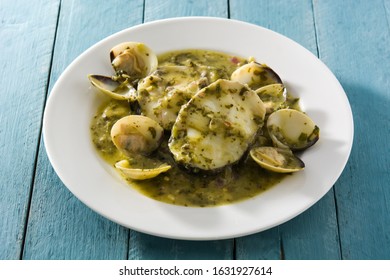 Hake Fish And Clams With Green Sauce On Blue Wooden Table