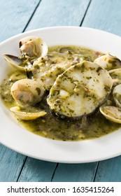 Hake Fish And Clams With Green Sauce On Blue Wooden Background