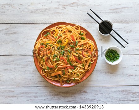 Hakka Noodles is a popular Indo-Chinese recipes. Schezwan Noodles with vegetables in a plate. Top view.  