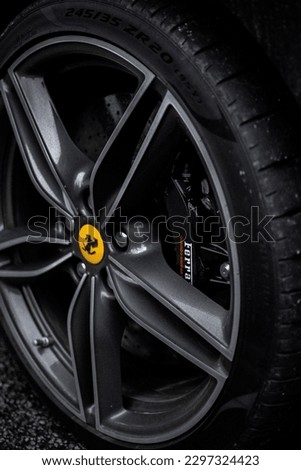 HALE, GB - May 17, 2022: A vertical closeup of a black Ferrari wheel in Hale Village, United Kingdom