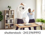 Half animal half people having fun at end of work week. Male corporate workers in horse and dinosaur masks having party. Funny happy men with weird horse and T rex dino faces dancing by desk in office