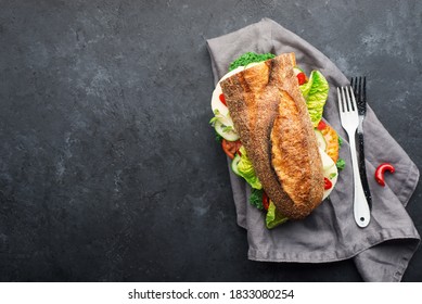 Half A Baguette For A Snack, Lunch, Dinner, Sandwich With Mozzarella Cheese, Fresh Vegetables And Lettuce With Hot Peppers On A Dark Background. Top View. Simple Comfort Food