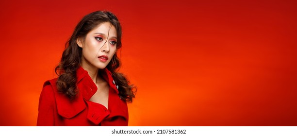 Half Body Portrait Of 20s Fashion Indian Woman Honey Skin Has Beautiful Black Hair Style. Asian Girl Express Strong Feeling, Fashion Poses Over Red Reddish Background Color Block