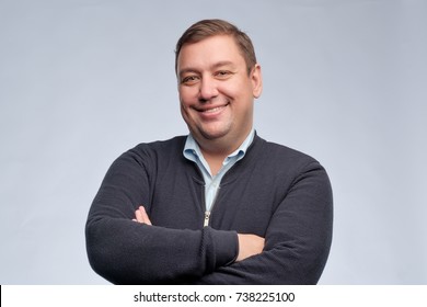 Half body portrait of confident caucasian middle aged man with folded arms looking at camera