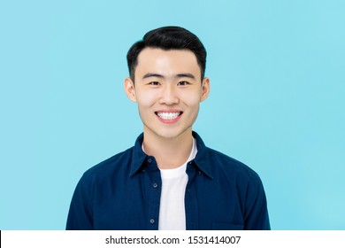 Half Body Portrait Of  Smiling Young Asian Man In Plain Casual Clothes On Light Blue Studio Background