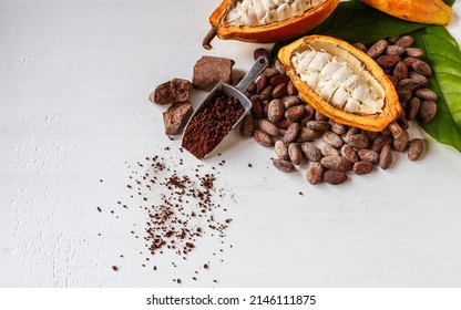 Half cacao pods with brown cocoa bean and brown cocoa powder on white background - Shutterstock ID 2146111875