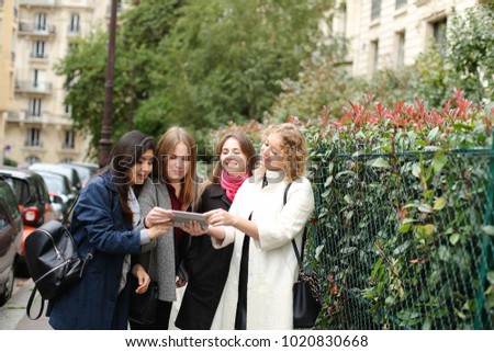 Similar – Image, Stock Photo Twin sisters take pictures of each other with smartphone at a bridge railing